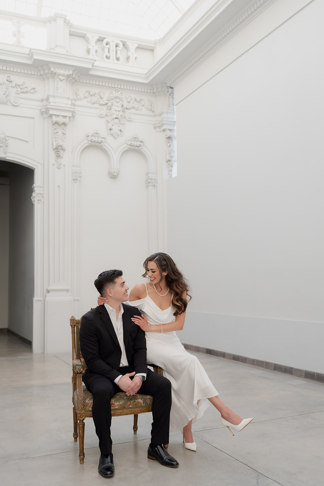 Kelsey Margarita and José Elías seated together in an ornate room